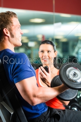 Personal Trainer in gym and dumbbell training