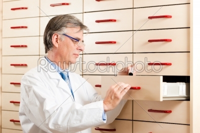 Pharmacist in front of medicine chest