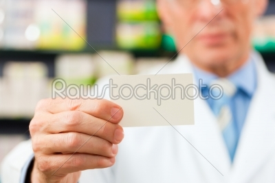 Pharmacist with business card in pharmacy