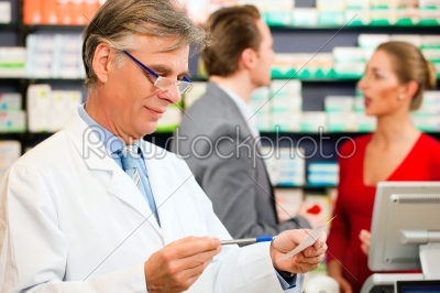 Pharmacist with customers in pharmacy