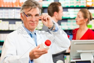 Pharmacist with customers in pharmacy