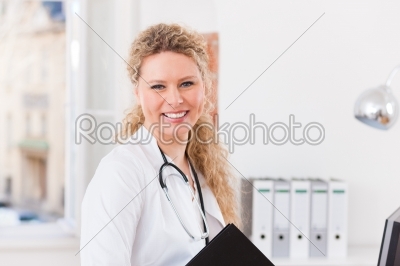 Portrait of young female doctor in clinic with file