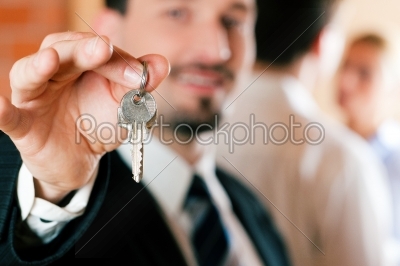 Realtor in apartment giving keys to couple