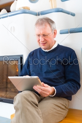 Senior at home in front of fireplace
