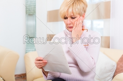 Senior at home receiving negative letter