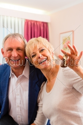 Senior couple sitting on bed in hotel room