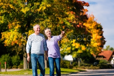 Seniors in autumn or fall walking hand in hand