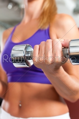 Sport - woman is exercising with barbell in gym