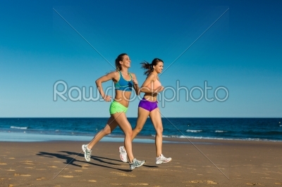 Sport and Fitness - people jogging on beach