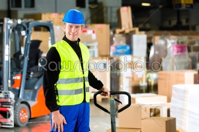 Storeman with mover at warehouse of forwarding