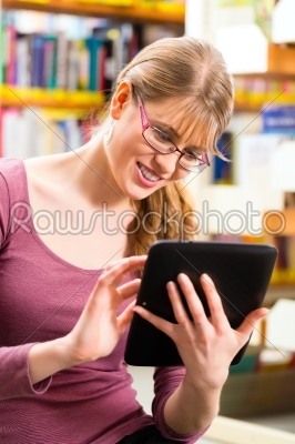 student in library learning with tablet computer