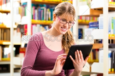student in library learning with tablet computer