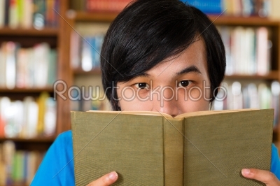 Student in library reading book