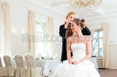 Stylist pinning up a bride_qt_s hairstyle