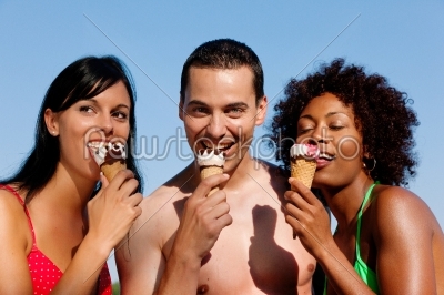 Summer - man and two women eating ice on beach