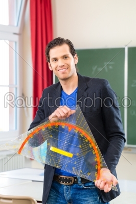 Teacher  with triangle in front of a school class