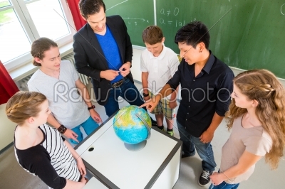 Teacher teaching students geography lessons in school