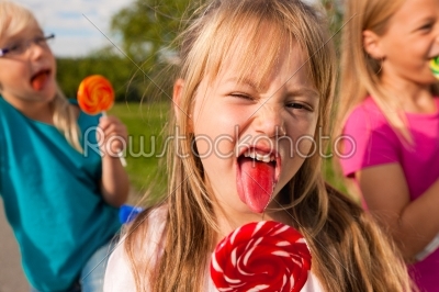 Three girls eating lollypops