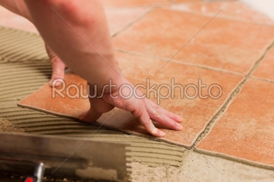 Tiler tiling tiles on the floor