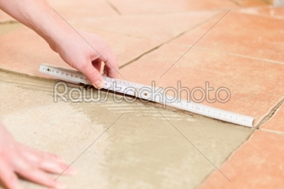 Tiler tiling tiles on the floor