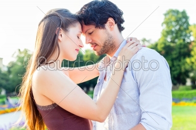 Tourist couple in city park hugging in love