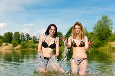 Two happy women having fun at lake