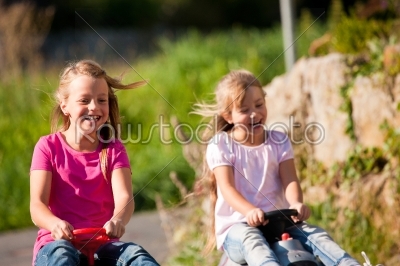 Two sisters with toy cars