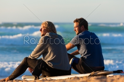 Two surfers talking on the beach