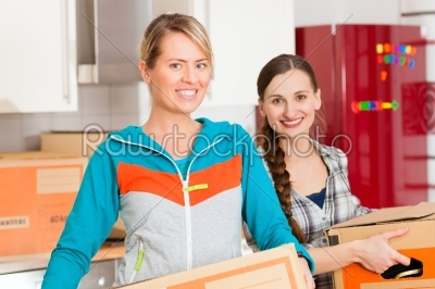 Two woman with moving box in her house