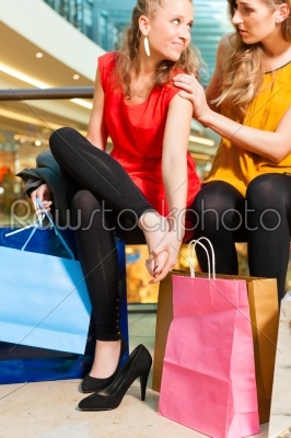 Two women friends shopping in a mall