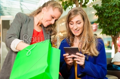 Two women shopping with bags in mall