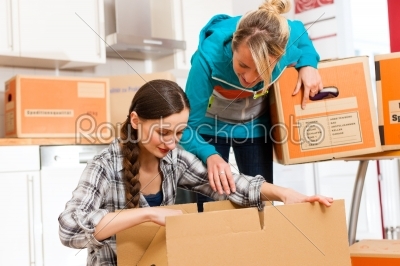 Two women with moving box in her house