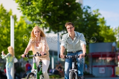 urban couple riding bike in free time in city