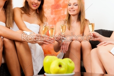 Wellness - female friends drinking champagne in spa