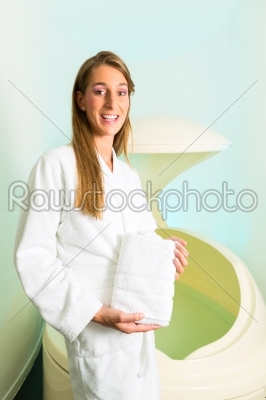 Wellness - young woman floating in Spa in Tank