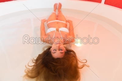 Wellness - young woman floating in Spa or swimming pool