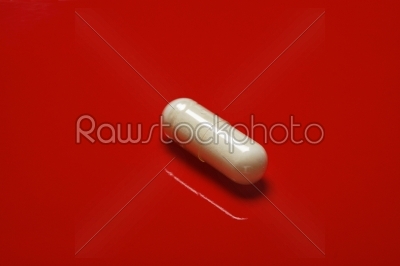 white pills on red background