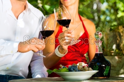 Woman and man in vineyard drinking wine