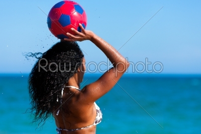 Woman at the beach playing soccer