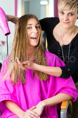 Woman at the hairdresser having hair dried 