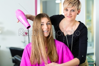 Woman at the hairdresser having hair dried 
