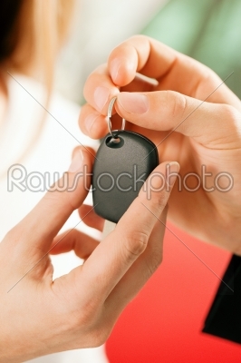 Woman buying car - key being given