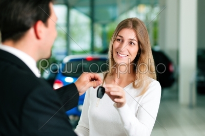 Woman buying car - key being given