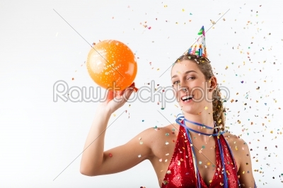 Woman celebrating birthday at a shower of confetti with balloon