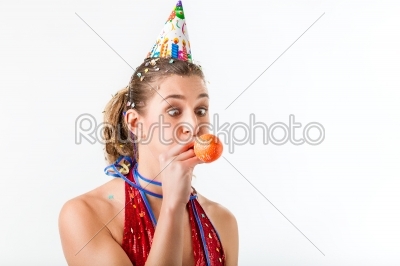 Woman celebrating birthday blowing up balloon