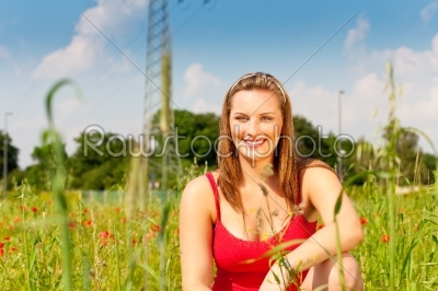 Woman cowering in meadow of field