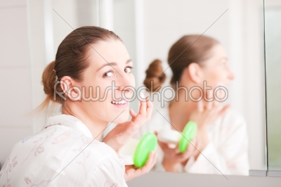 Woman creaming her face 