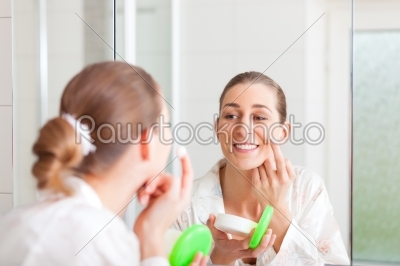 Woman creaming her face