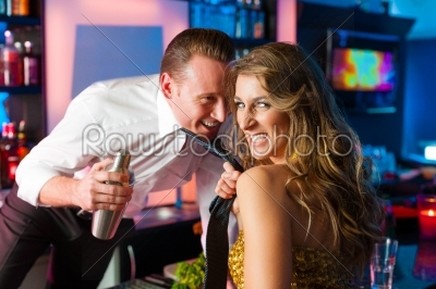 Woman dragging barkeeper in club or bar