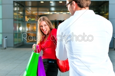 Woman dragging man into shopping mall